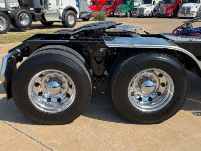 Kenworth W900L chassis with dual rear tires and chrome wheels, side view of the driveline area.