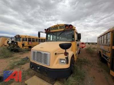 Front view of a 2007 Freightliner FS65 school bus in a used lot, yellow body, black grille, stop sign visible, other buses in background.
