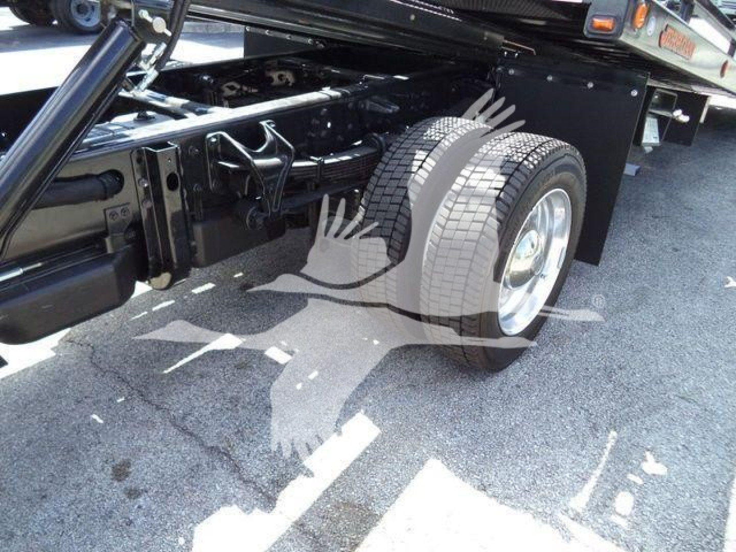 Truck undercarriage view showing rear dual wheels and suspension components of a 2023 International CV rollback truck.