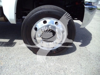 Truck wheel with tire and chrome wheel cover visible in the front wheel well.
