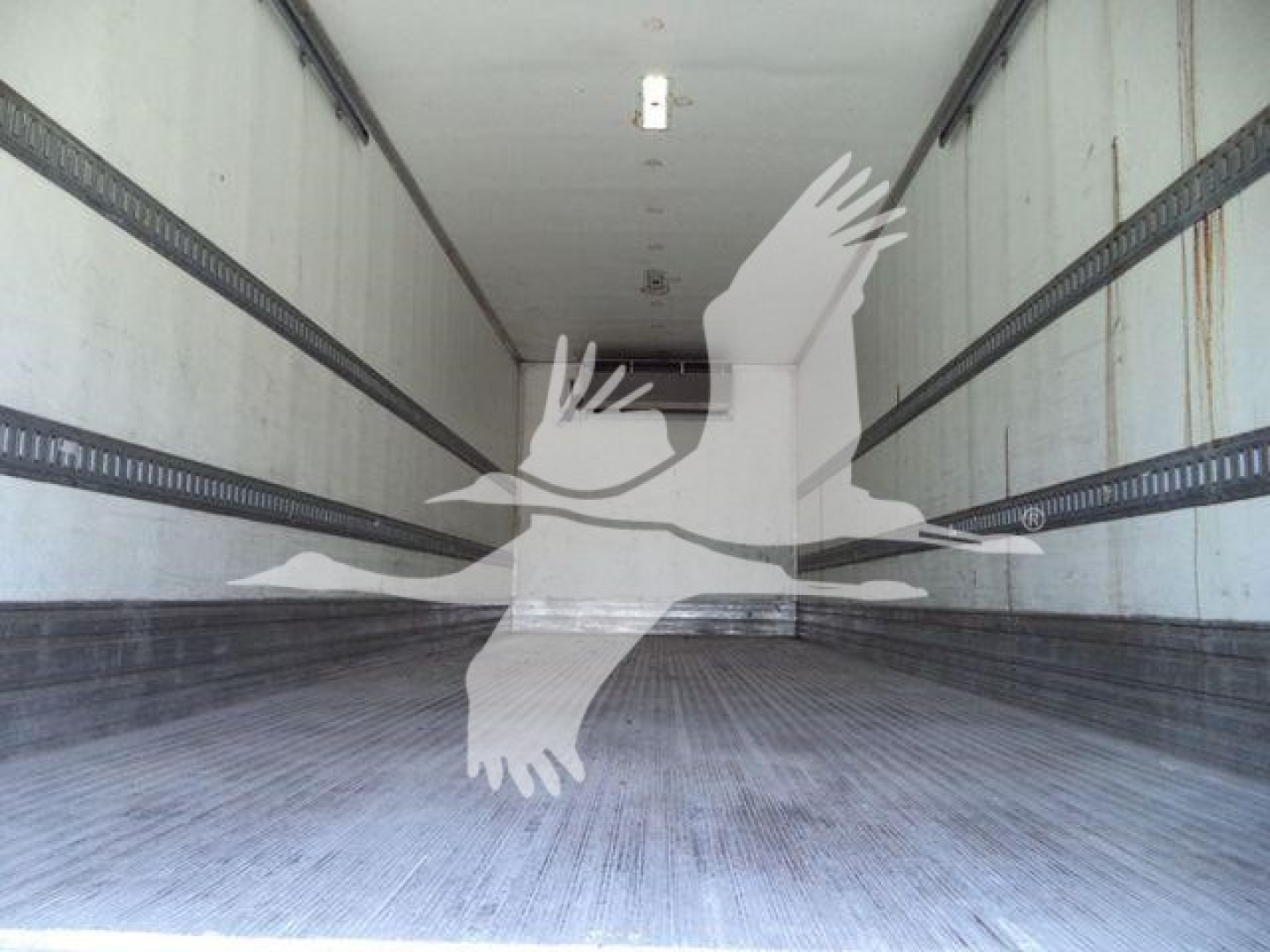 Interior of a refrigerated straight truck trailer with metal side walls and ribbed floor, empty with a watermark overlaid.