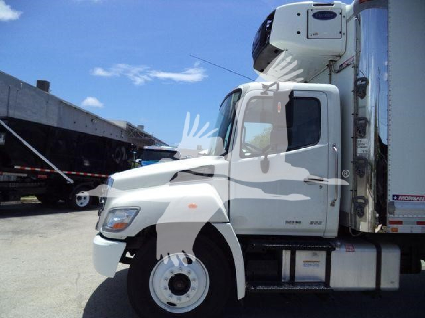 Hino 268A refrigerated truck cab and trailer in side view showing front wheel and refrigeration unit on top.