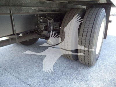 Rear axle and dual tires of a 2019 Hino 268A refrigerated truck showing suspension components and tire tread.