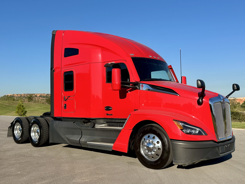 Kenworth T680 sleeper cab truck in red, side view showing tractor with tandem rear axles and chrome wheels.