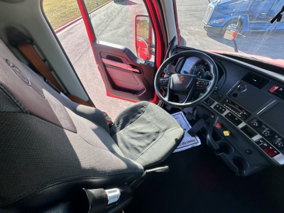 Kenworth T680 cab interior showing driver's seat, steering wheel, and dashboard with controls.