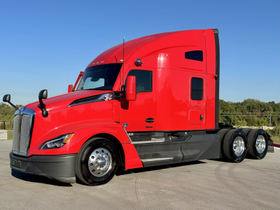 Kenworth T680 conventional sleeper truck in red, side view showing cab, dual rear axles, and chrome wheels.
