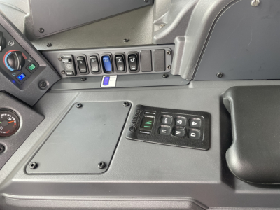 Cab interior of a 2026 Mack TE64 showing dashboard controls with panel of switches and a gear selector labeled P R N D plus 4 buttons.