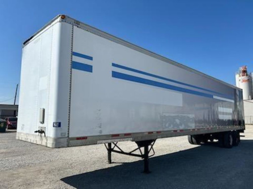 Trailer side view showing white 2000 Trailmobile van with blue stripes and raised landing gear in foreground.