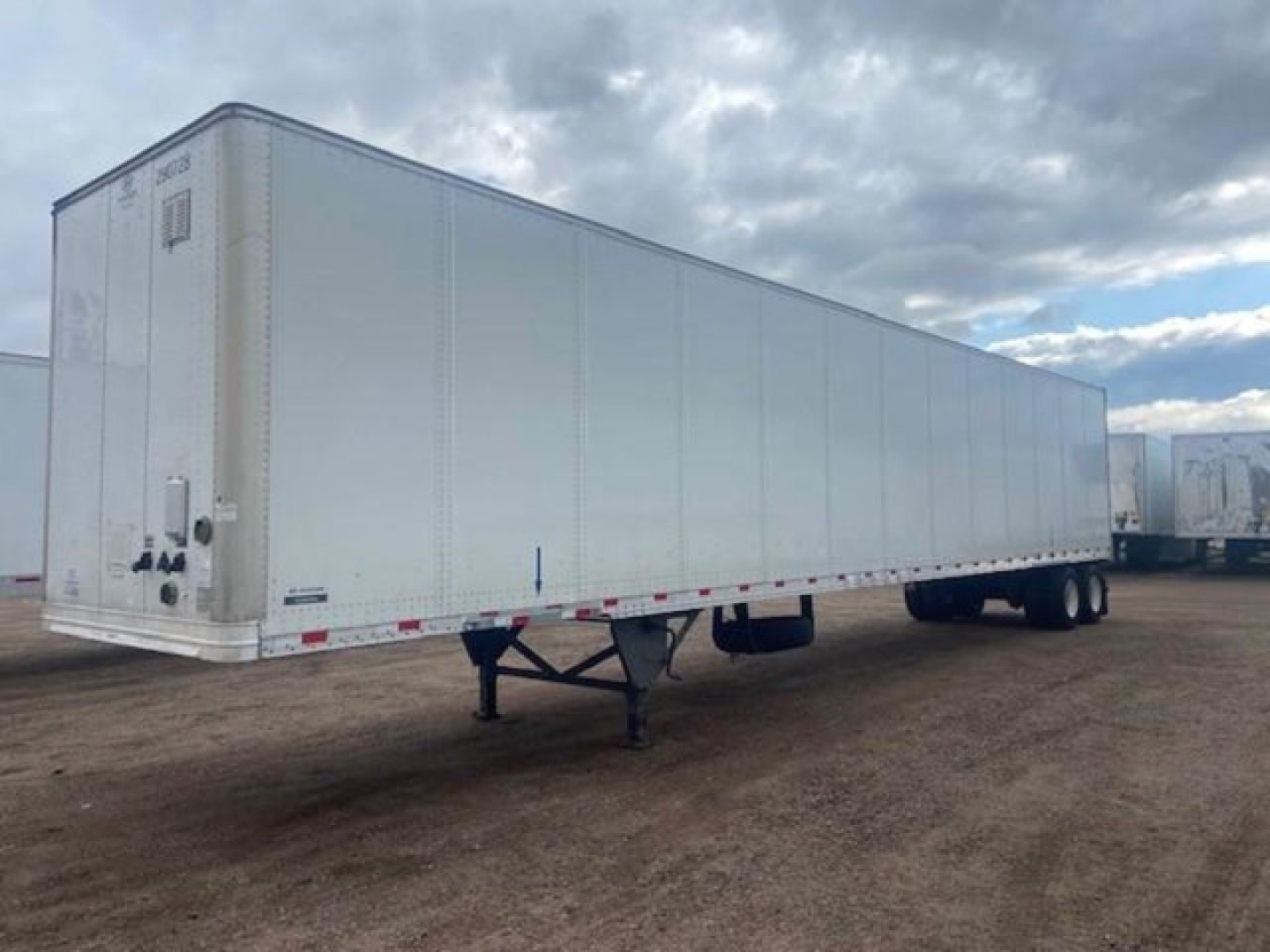 Trailer side view showing white 53' dry van trailer with front doors and landing gear.
