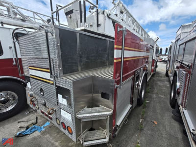 Fire truck rear/right side view showing aluminum diamond plate and compartments on a ladder truck with ladder bay and utility steps.
