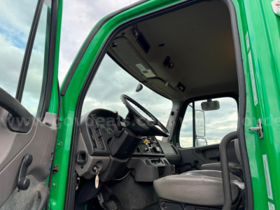 Cab interior of a 2021 Freightliner Bearcat asphalt truck showing steering wheel, dashboard, and driver seat from the open door.
