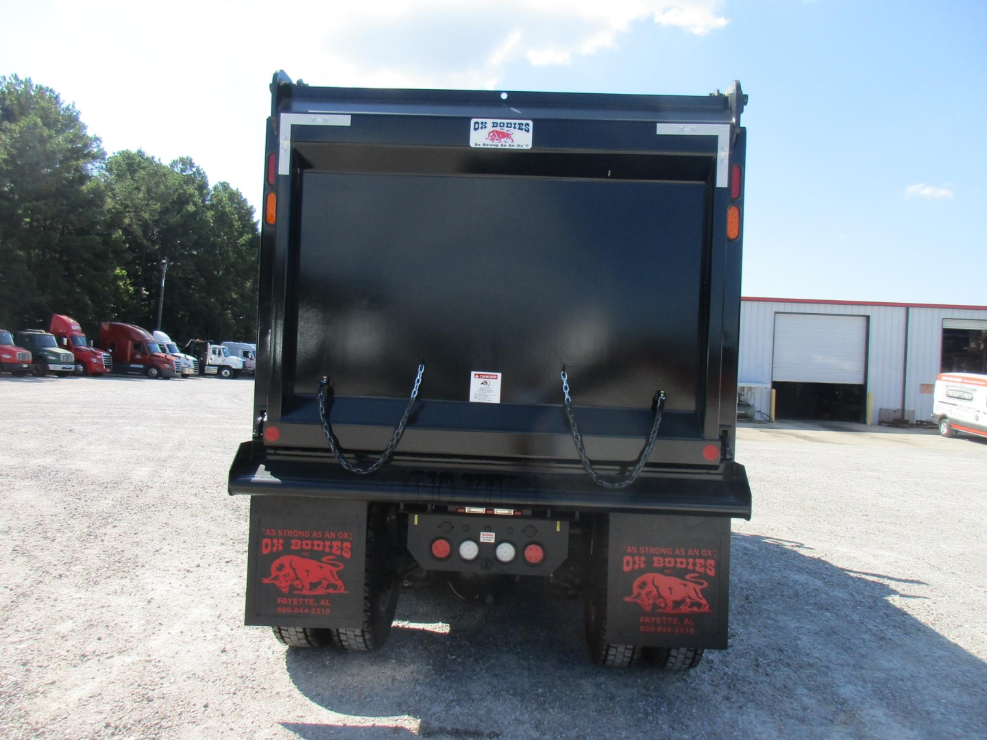 Western Star 49X dump truck rear view showing dump bed and taillights with mud flaps and bumper area