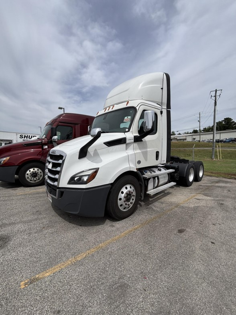 Cabover view of a 2020 Freightliner Cascadia 116 day cab tractor showing front and side, white with sleeper roof, without trailer.