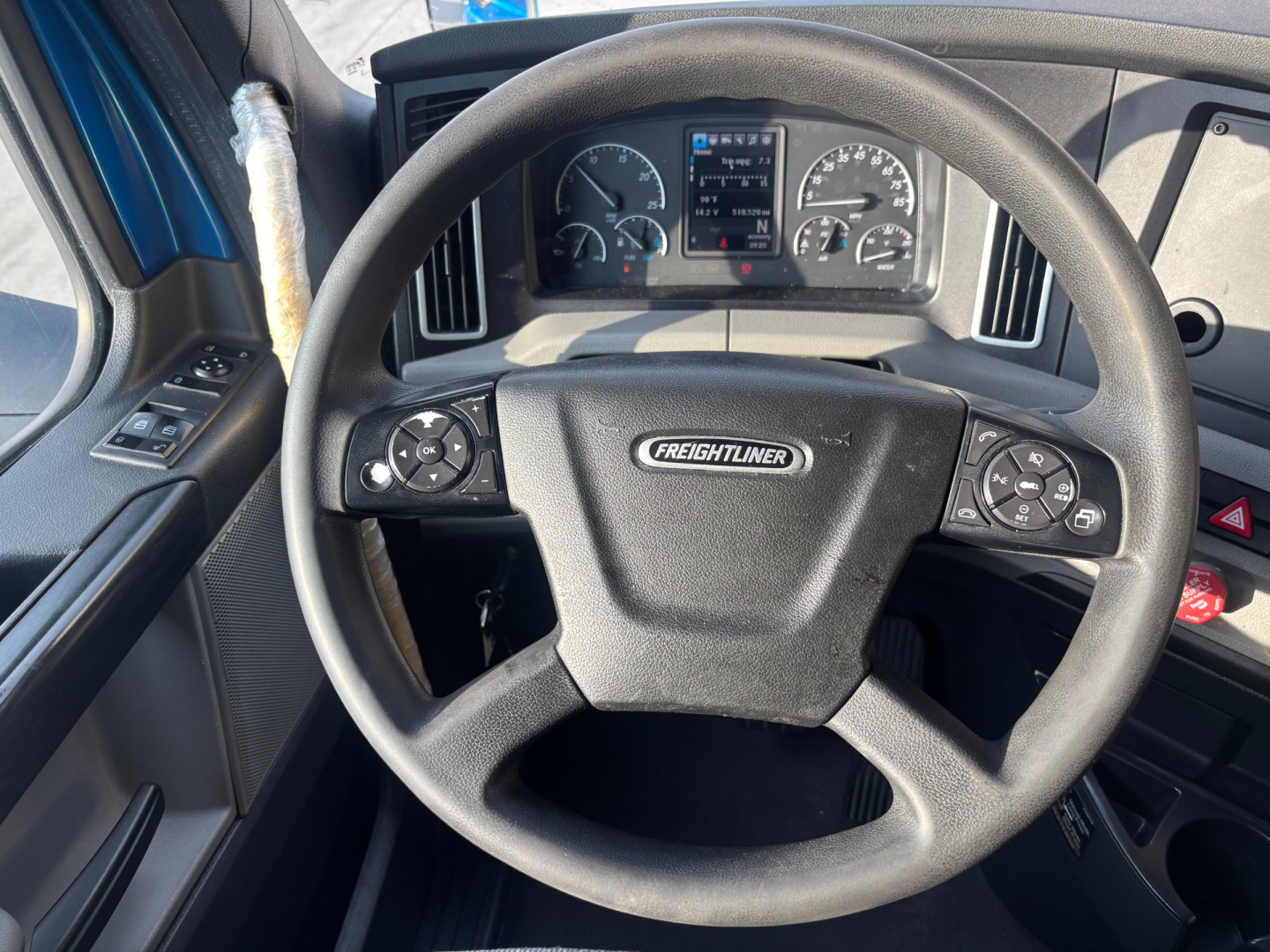 Freightliner PT126064ST truck steering wheel and dashboard showing Freighliner emblem and instrument cluster.