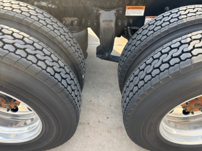 Dual rear wheels of a Freightliner heavy truck showing dual tires and axle assembly.