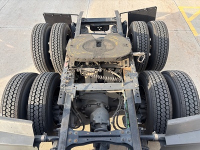 Rear view of a Freightliner PT126064ST truck chassis showing dual rear axles with six wheels, frame rails, drivetrain, and suspension components.
