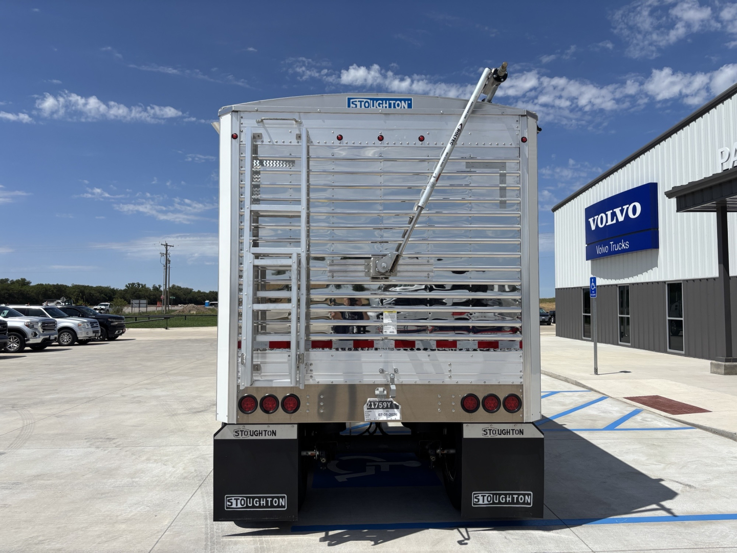 Stoughton 43' aluminum grain hopper trailer rear view showing 80" sidewalls, Stoughton branding, taillights, mud flaps, and a hydraulic auger chute.
