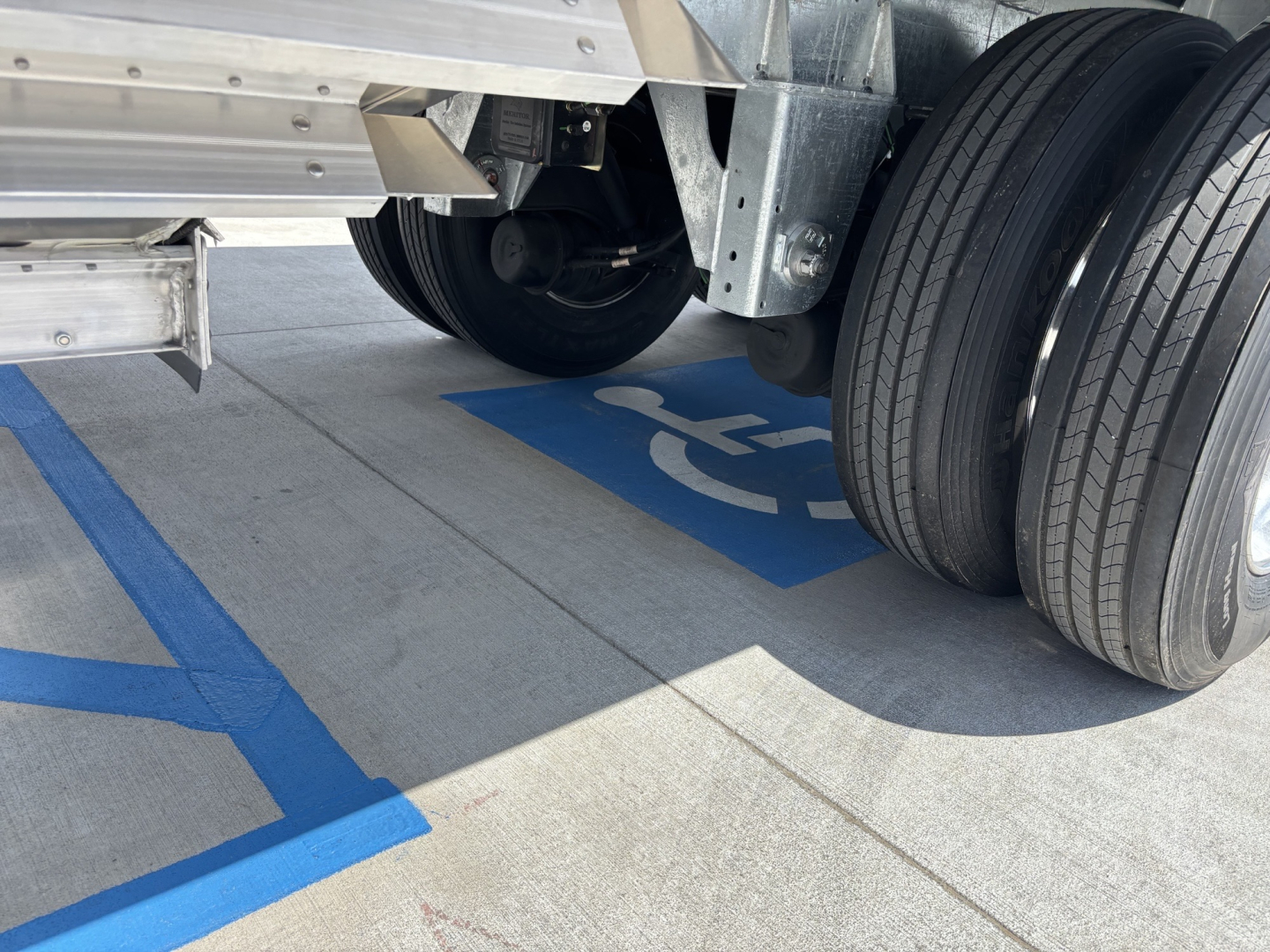 Trailer wheel assembly and undercarriage of a 2026 Stoughton 43' aluminum grain hopper showing dual rear tires and metallic framework