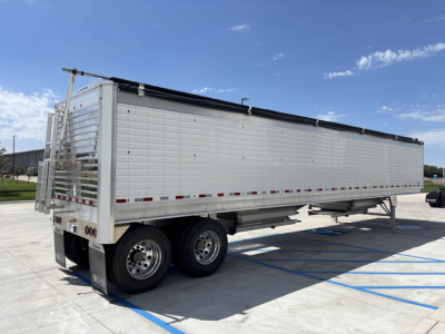 Stoughton 43' aluminum grain hopper trailer with 80-inch sides, tandem axles, rear access ladder, and tarp system, parked on concrete.