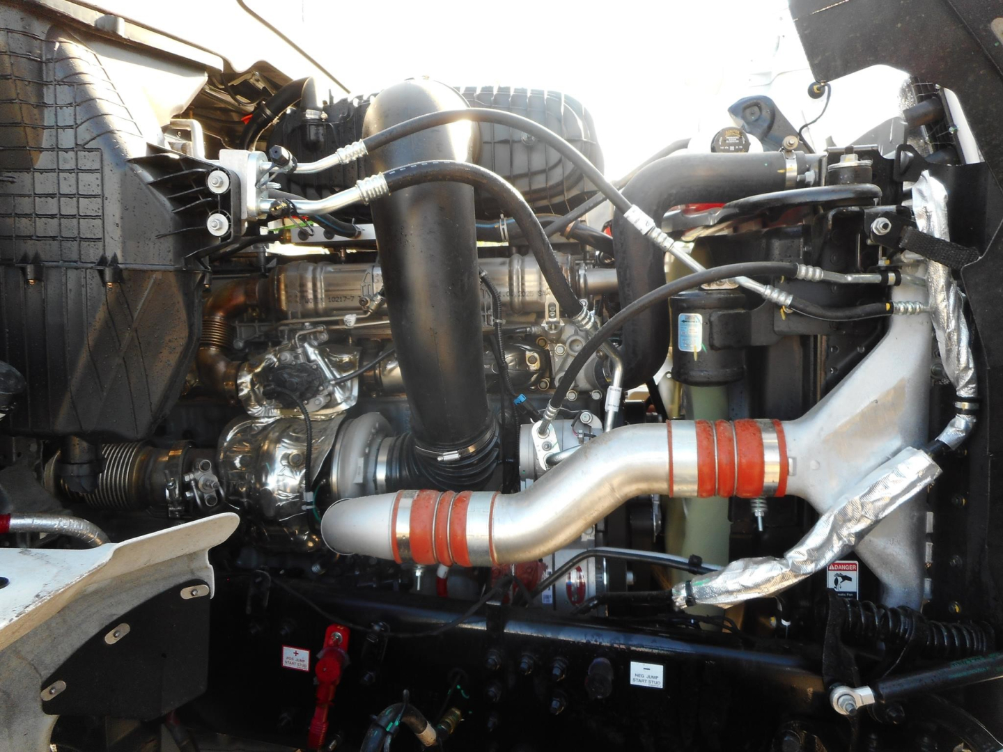 Western Star 49X engine bay showing turbo piping, hoses, and various components.
