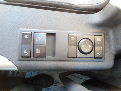 Trucks interior control panel showing window/seat adjust switches and circular multi-function dial inside a 2026 Western Star 49X cab.