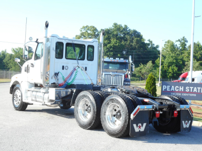 White Western Star 49X day cab truck in a dealership lot, side view showing tractor rear and dual rear axles with chrome exhaust stacks