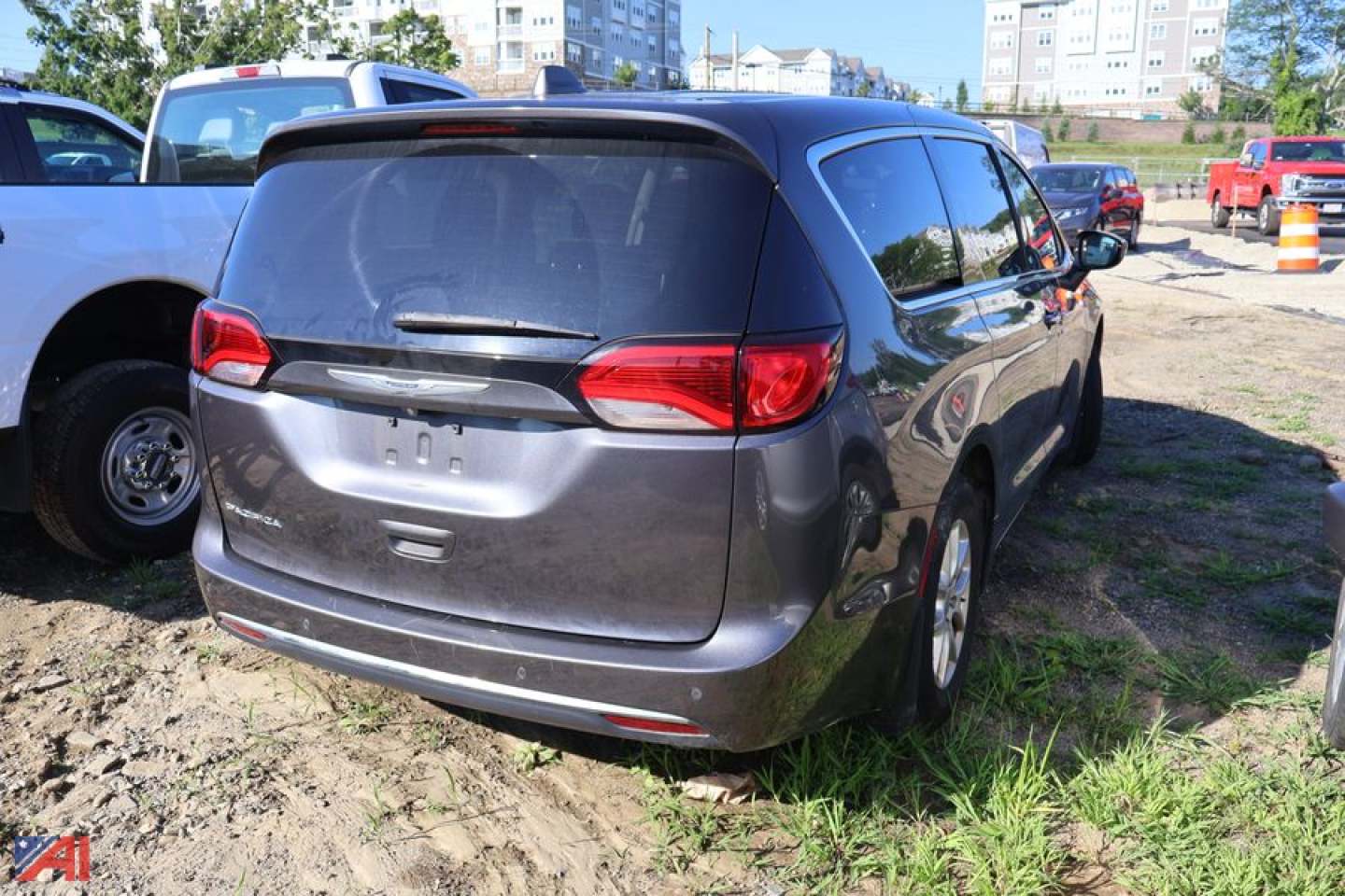 Chrysler Pacifica minivan rear view showing tailgate and taillights in a used vehicle lot.