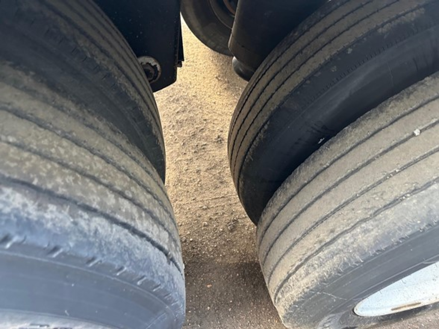 Trailer tires close-up view showing dual rear wheels with tread and wear bands visible on the tires