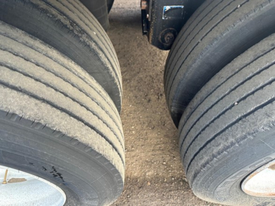 Trailer axle showing dual tandem wheels with dusty rubber tires and rims for a 2010 Wilson Pacesetter hopper trailer