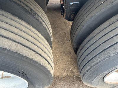 Trailer tires and hub area of a Wilson Pacesetter hopper trailer showing dual axles and worn tread grooves.