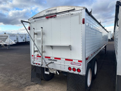 Gooseneck Wilson Pacesetter hopper trailer back view showing twin axles and rear bumper with lights.