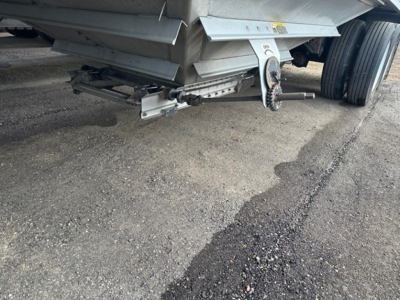 Trailer hitch and underside of a Wilson Pacesetter hopper trailer showing linkage and dual wheels.