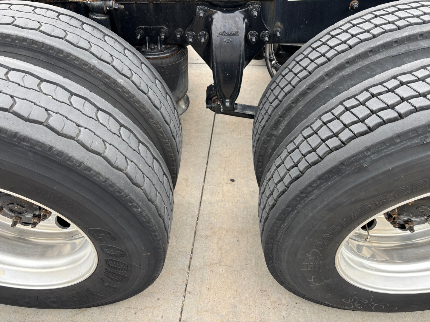 Freightliner chassis showing dual rear axles and suspension from a low angle.