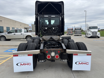 Truck chassis back view showing fifth-wheel and dual rear axles in a Freightliner cab, with MHC mud flaps.