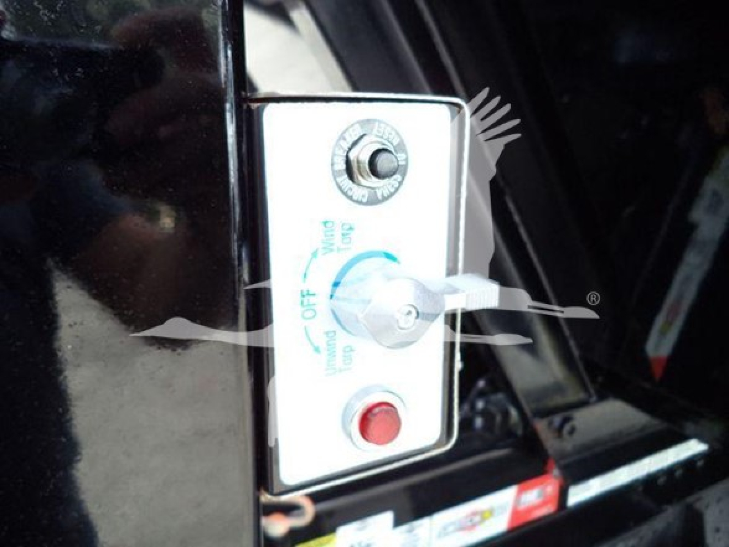 Isuzu NRR cab door area with control panel showing ignition switch and red push button, part of rollover truck.