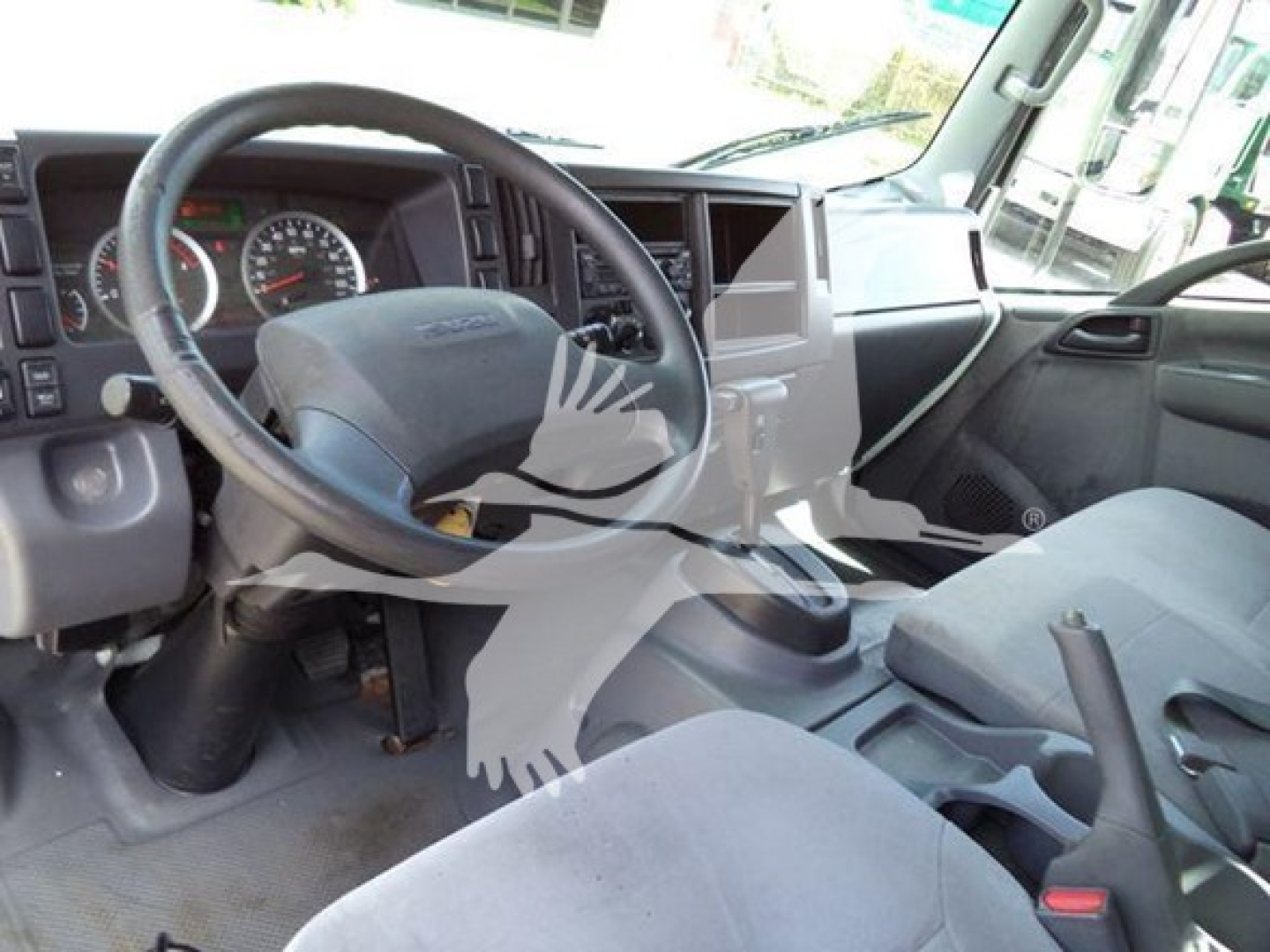 Isuzu NRR truck interior showing steering wheel, dashboard, and front seats.