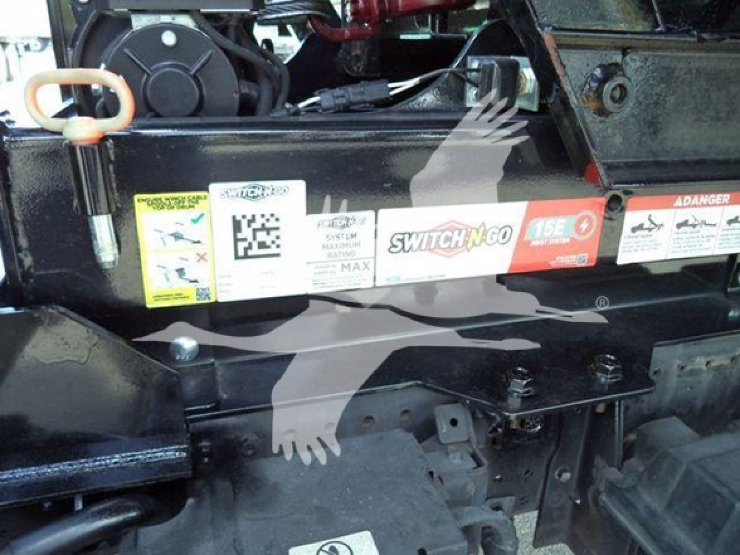 Isuzu NRR component area showing stickers and labels on a truck chassis, including a prominent 'SWITCH-N-GO' label and safety/maintenance decals.