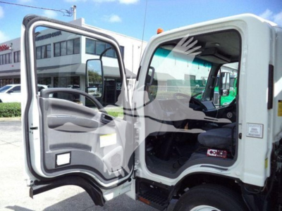 Isuzu NRR truck cab interior with door open showing steering wheel, seat, and dashboard; exterior white cab, rolloff configuration.