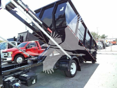 Isuzu NPR/NRR truck dump bed in raised position showing rear wheels and hydraulic lifting mechanism.