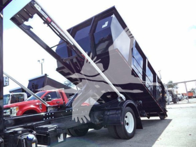 Isuzu NRR dump truck with hydraulic lift and black dump bed, side view showing raised cargo bed and wheel