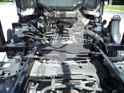 Isuzu NRR engine bay view showing exposed engine components and front chassis rails.