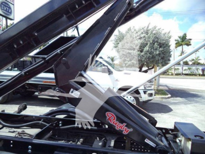 Isuzu NRR truck with roll-off hoist and Reach truck arm showing 'Raugh?' brand decal on black hydraulic arm in a dealership lot