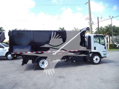 Isuzu NRR roll-off truck side view showing cargo bed with black container and white cab.