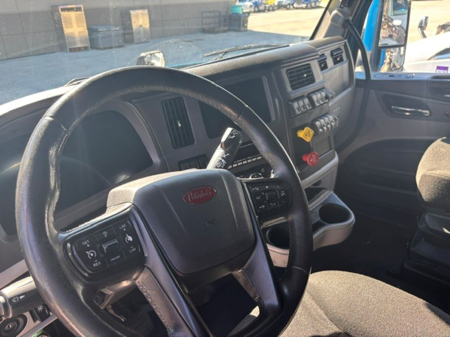 Peterbilt 579 truck interior steering wheel and dashboard view from driver seat with steering column controls and center console.