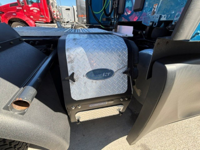 Peterbilt 579 engine bay showing diamond plate toolbox with Peterbilt logo and Compton box, side of cab, metallic surface.