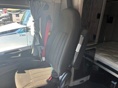 Peterbilt 579 sleeper cab interior with driver seat and curtain visible, diesel truck cabin details in view.