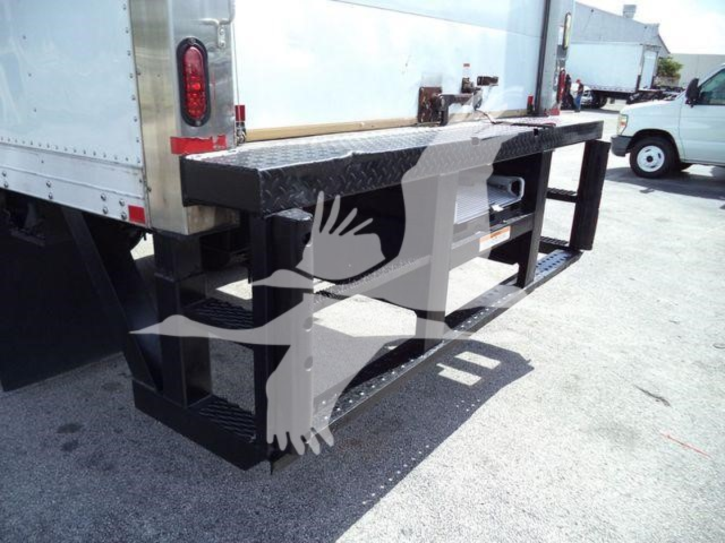 Rear view of a used 2015 Hino 268A refrigerated truck with a black steel bumper and undercarriage, showing the tail area and dock platform.
