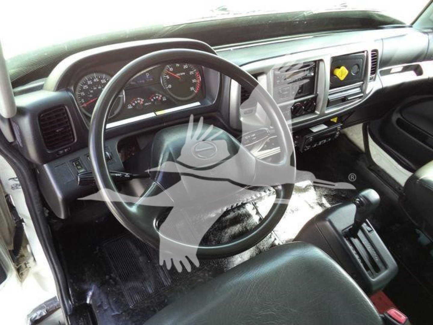 Cab interior of a 2015 Hino 268A showing steering wheel, dashboard, and center console with gauges and infotainment screen.