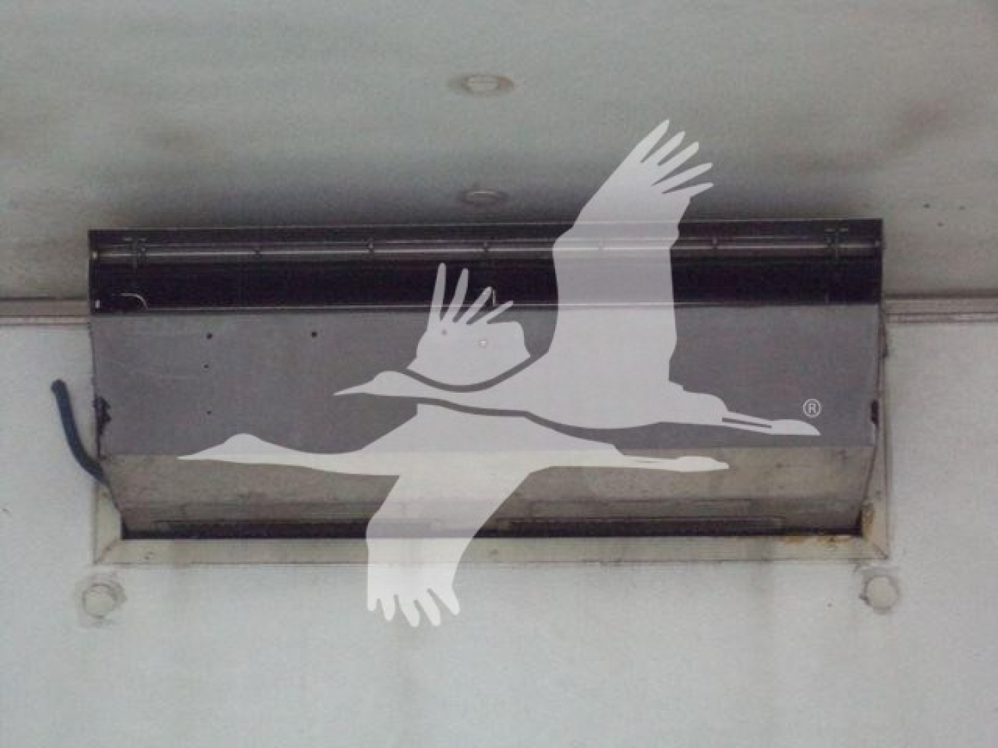 Cabin refrigeration unit mounted under trailer with a large logo of a flying seagull overlaying the image.