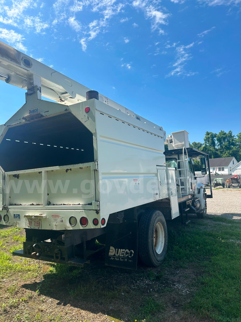 Rear and side view of a white international 4300 dump truck with open bed, showing rear tailgate and wheels; some text on mudflap and tailgate hints at equipment brands.